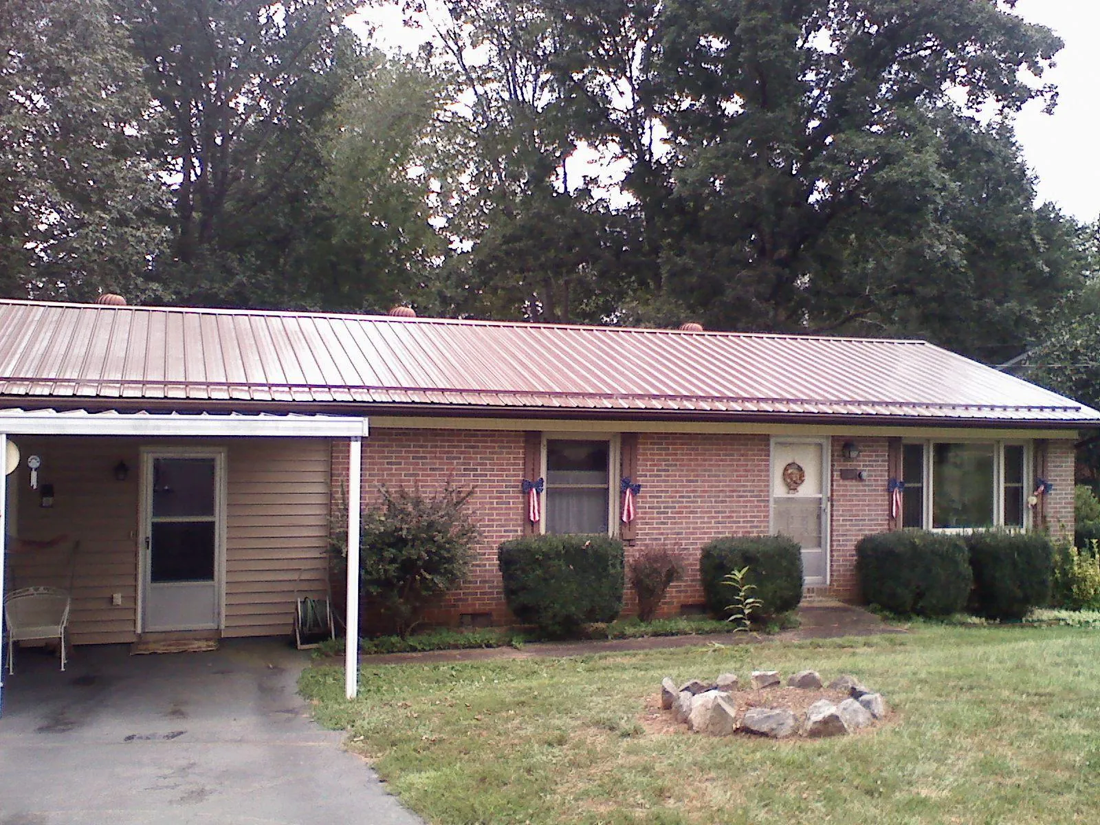 Bronze metal roof and carport on a brick ranch home — Roof Repair work by our crew in Parlier