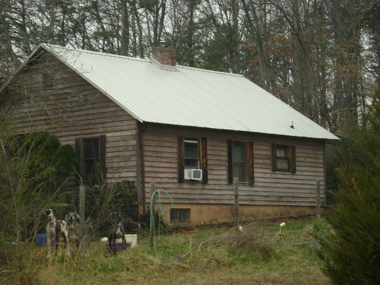 White metal roof on an old wood sided farmhouse, from a Metal Roof Installation job in Parlier